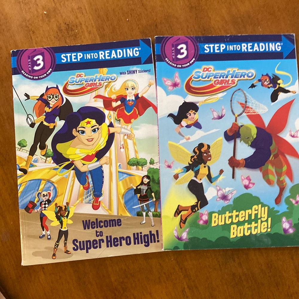 2 paperback books- super hero girls